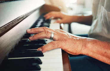 Gordijnen Hands, piano and senior man playing for music in living room for musical entertainment practice. Instrument, hobby and elderly male person in retirement enjoying a song on keyboard at modern home. © aLListar/peopleimages.com