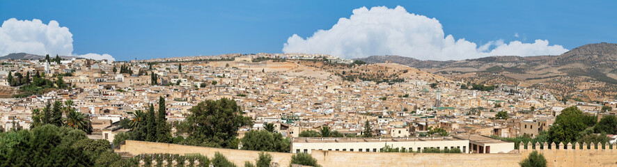 Fototapeta na wymiar Beautiful panoramic view of the old Medina in Fes, Morocco (Fes El Bali Medina), a sea of buildings made of earthy tones. It's a bustling maze of life, with people and markets nestled in its heart