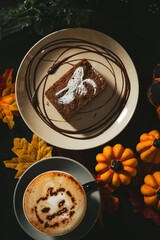 Spooky Brownie with ghost art and Halloween cappuccino coffee with a scary spooky pumpkin latte art and decorations