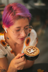 Cool Girl holding a Halloween cappuccino coffee with a scary spooky pumpkin latte art