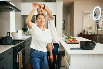 Happy couple, together and dancing while cooking in kitchen for fun, energy or bond in romance....