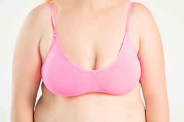 Large natural saggy breasts with asymmetry after breastfeeding in a pink top bra close-up, big...