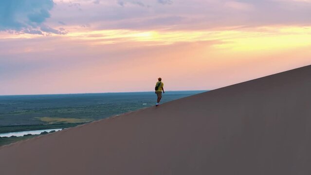 Man walking on the dune of the desert