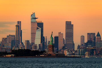 Obraz premium Cityscape landscape in golden hour about New York. included the Statue of liberty. Lady liberty is on the middle New York Skyscrapers is on the background included the famous Edge observation deck too