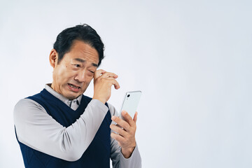 スマホを見て泣くミドル男性