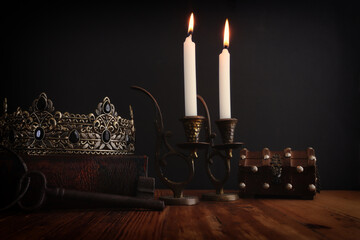 low key image of beautiful queen or king crown over antique book. vintage filtered. fantasy medieval period