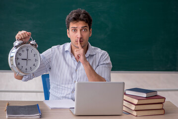 Young male teacher in time management concept