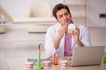 Young male dentist working in the clinic