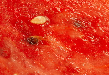 Red watermelon flesh with black pips. Red pulp of cut watermelon with black and white seeds in...