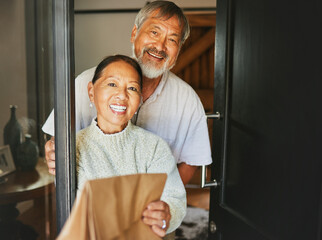 Couple, smile and happiness with front door for food delivery by service to house for retirement....