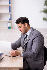 Fototapeta premium Young male employee working in the office