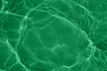 Defocus blurred transparent green colored clear calm water surface texture with splashes reflection. Trendy abstract nature background. Water waves in sunlight with copy space. Blue watercolor shine.