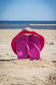 Accessories for relax on beach. Straw hat and flip flop. Summertime