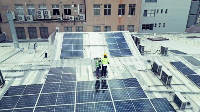 Construction, team or aerial view with solar panel on building for engineering, design and inspection. Photovoltaic, people or planning or blueprint with discussion, conversation or talking outdoor