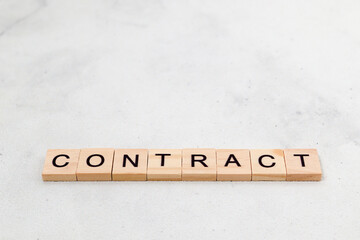 Top view of contract word on wooden cube letter block on white background. Business concept