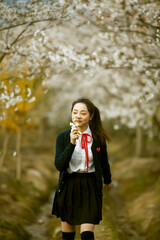 Asian girl playing under the beautiful plum tree