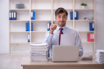 Young male employee and too much work in the office