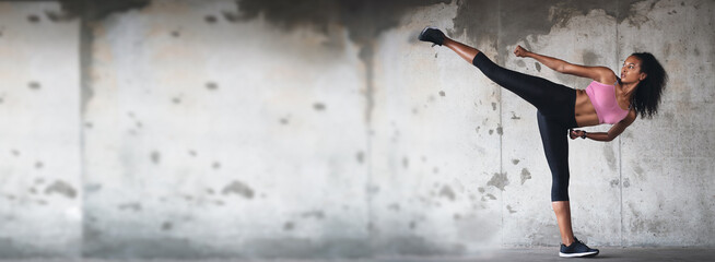 Fitness, woman and karate kick on banner for athletic, sport or martial arts outdoor for workout or exercise. Training, athlete and kickboxing for wellness, healthy body or cardio on mockup space © aLListar/peopleimages.com