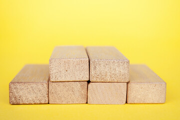 Stack of wooden blocks on yellow cover with customizable space to insert text. Copy space