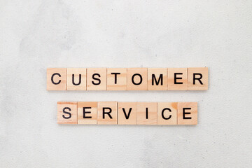 Top view of Customer Service word on wooden cube letter block on white background. Business concept