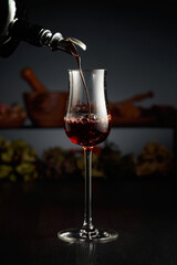 Brown herbal liquor or rum is poured from a vintage bottle.