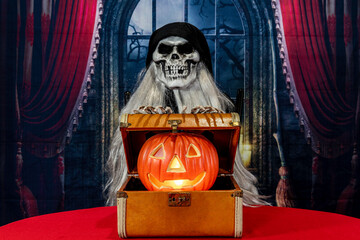 Halloween jack-o-lantern in vintage suitcase on red with grim reaper and spooky night window...
