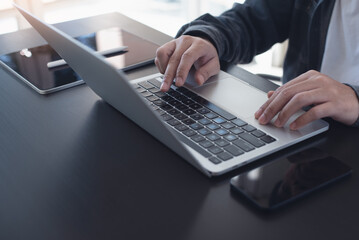 Business man hands typing on laptop computer keyboard and surfing the internet on office table, online working, business and technology, internet network concept