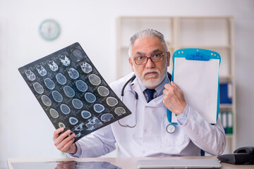 Old male doctor radiologist working in the clinic