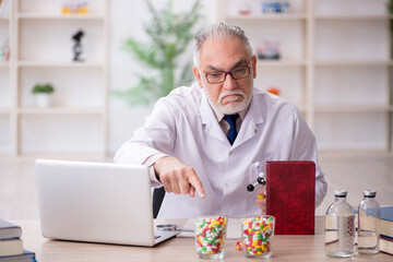 Old male doctor holding molecular model