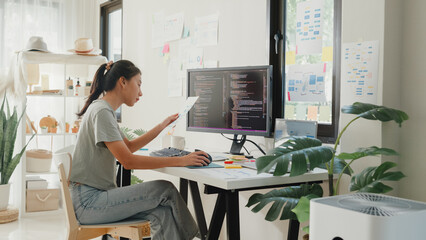 Side view of professional young Asia girl IT development programmer typing on keyboard coding...