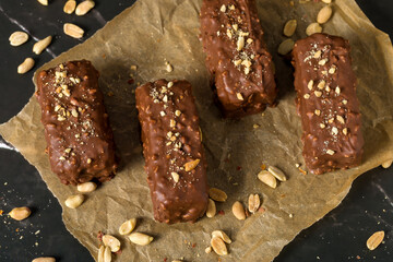 Chocolate sticks with peanuts on a dark background