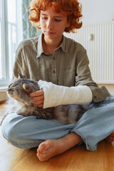 teenager with broken arm in cast and pet cat