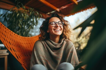 A woman enjoying a relaxing moment in a hammock with a cheerful smile
