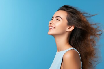 A smiling woman with long hair looking upwards