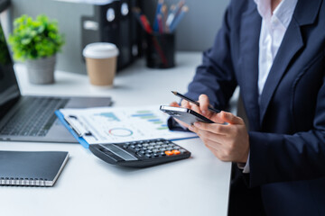 Close-up woman hand press calculator to calculate the company's financial results, tax, accounting,...