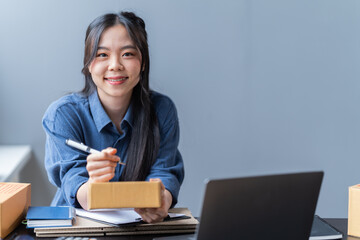 startup girl Small SME business owners work with laptop computers at work. with parcel paper boxes for delivery to customers online selling, Ecommerce,