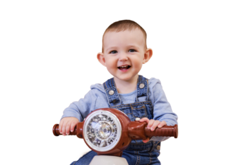 Happy baby boy rides a plastic children motorcycle in the playroom, isolated on a white background. A smiling child drives a moped toy, isolated on a white background. Kid age one year