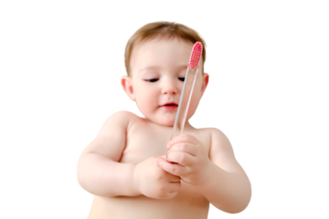 Child cleans his mouth with a toothbrush in his hands, isolated on a white background. Happy toddler baby learns to brush her teeth while lying on her home bed. Kid aged one year