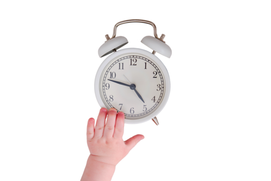Baby toddler boy holds an alarm clock in his hand, isolated on a white background. Child with a white alarm clockt, close-up
