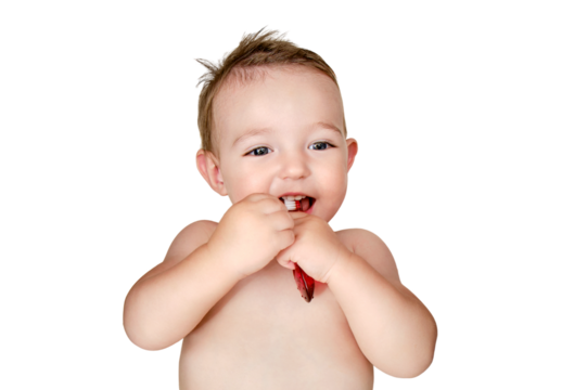Happy toddler baby brushes his teeth with a toothbrush, isolated on a white background. A smiling child boy cleans his teeth with a brush on his own, isolated on a white background. Kid age one year