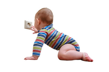 Baby toddler reaches into the electrical outlet on the home wall with his hand, isolated on a white background. Danger and protection of child fingers from electric shock
