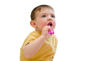 The baby's dental hygiene is being taken care of as she brushes her teeth in the crib, isolated on white background. Kid aged about two years (one year eleven months)