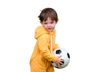 A young child is actively playing soccer in the park, isolated on white background. Kid aged two years (two-year-old boy)