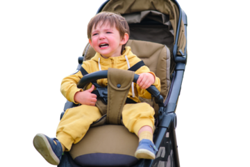 The unhappy child's face shows stress as he crying in the stroller during the park walk, isolated on white background. Kid aged two years (two-year-old boy)