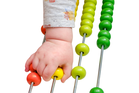 Toddler baby boy plays with his hands with colorful abacus on the floor, isolated on a white background