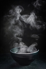 Steam of hot soup with smoke wood bowl on dark background.selective focus.hot food concept - obrazy, fototapety, plakaty