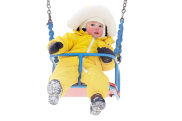 Happy toddler baby rides on a swing on a winter playground, isolated on white background. Baby boy in yellow snowsuit swinging in kindergarten. Kid age one year eight months