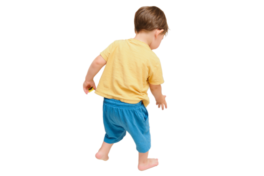 The child is putting the toys back in the box after playing, isolated on white background. Kid toddler boy aged two years
