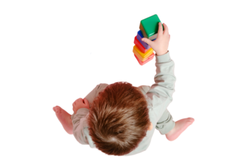 Happy toddler baby plays with cubes on studio, isolated on white background. Child boy builds a tower of toys, isolated on white background. Kid age one year eight months