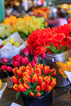 Buckets and bouquets of colorful bright spring tulips from local growers for sale at the famous farmer's market in Seattle, Washington, USA